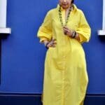 Model in Yellow Relaxed buttoned down dress posing front